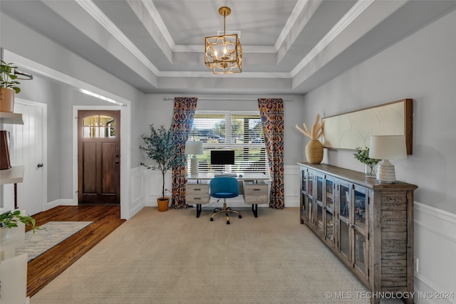 office area with a raised ceiling, ornamental molding, and a chandelier