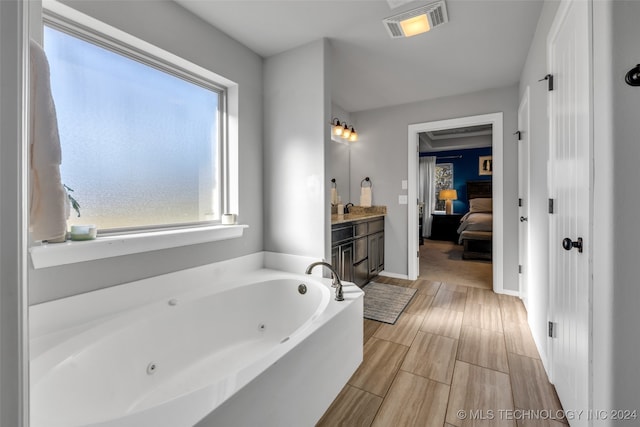 bathroom with a washtub and vanity