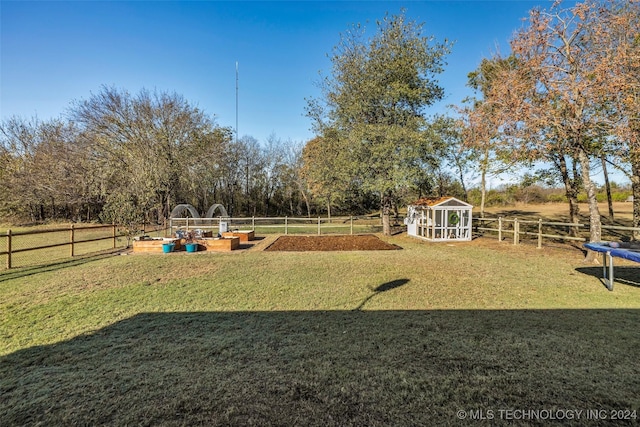 view of property's community featuring a vegetable garden and an outdoor structure