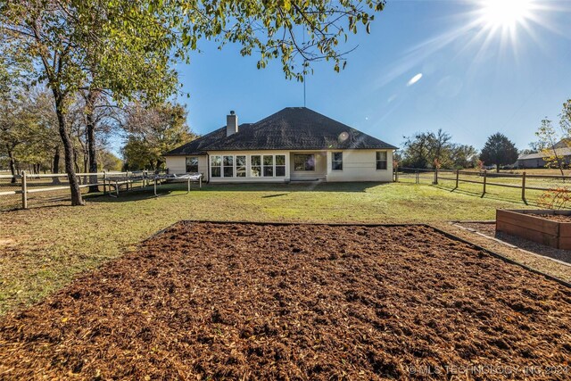 rear view of property featuring a garden and a chimney
