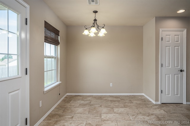 unfurnished dining area featuring a chandelier