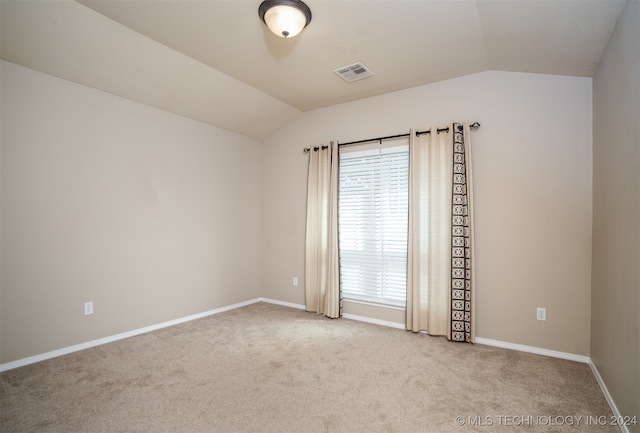 carpeted empty room with lofted ceiling