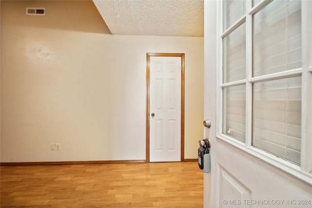 empty room featuring a textured ceiling and light wood-type flooring