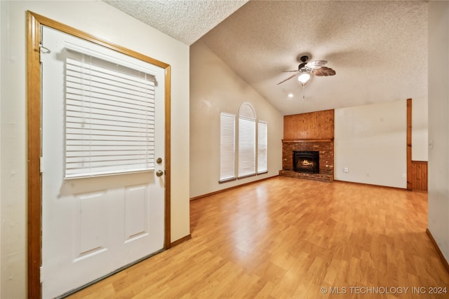 unfurnished living room with lofted ceiling, a textured ceiling, ceiling fan, and light hardwood / wood-style flooring