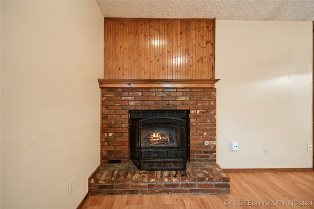 details with hardwood / wood-style flooring, wooden walls, and a textured ceiling