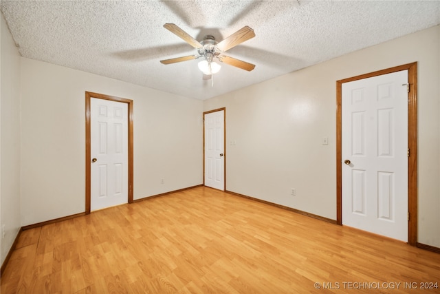 empty room featuring light hardwood / wood-style floors, ceiling fan, and a textured ceiling