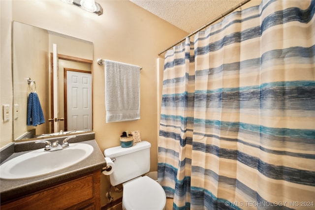 bathroom featuring walk in shower, vanity, toilet, and a textured ceiling