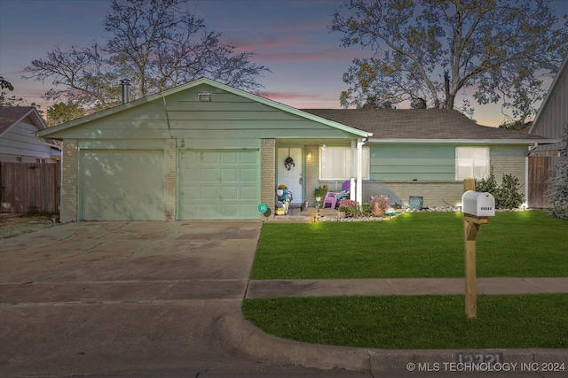 ranch-style home featuring a garage and a yard