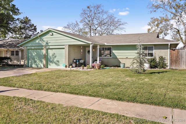 ranch-style house featuring a garage and a front lawn