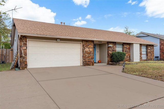 ranch-style home with a garage and a front lawn