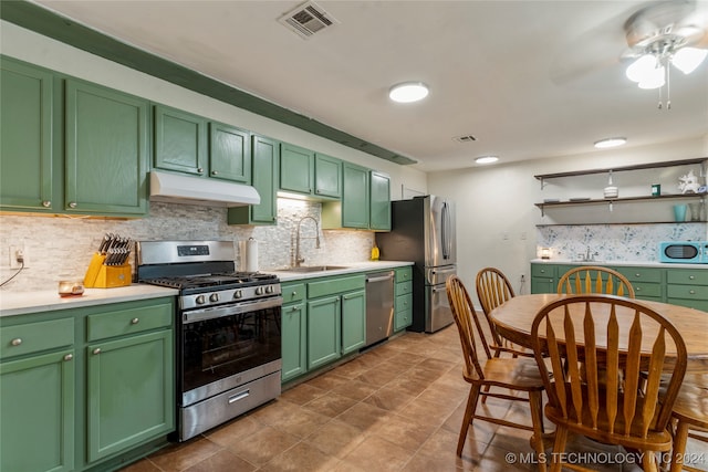 kitchen with decorative backsplash, appliances with stainless steel finishes, green cabinetry, and sink