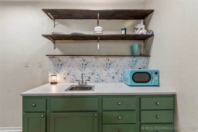 bar featuring green cabinets and sink