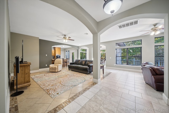 tiled living room featuring ceiling fan and a wealth of natural light