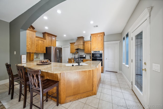 kitchen featuring kitchen peninsula, custom exhaust hood, a breakfast bar, stainless steel appliances, and sink