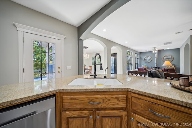 kitchen with stainless steel dishwasher, ceiling fan with notable chandelier, and sink