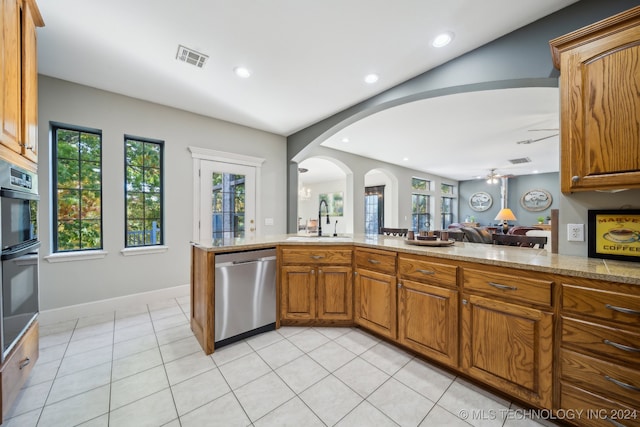 kitchen featuring kitchen peninsula, stainless steel dishwasher, a wealth of natural light, and sink