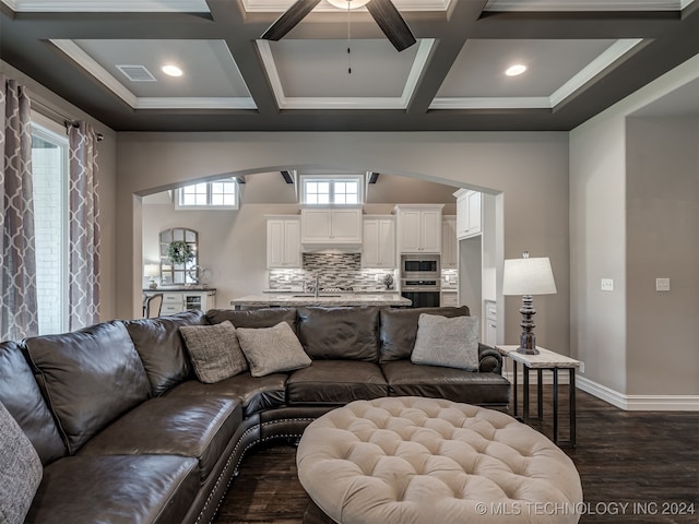 living room with plenty of natural light, dark hardwood / wood-style floors, sink, and coffered ceiling