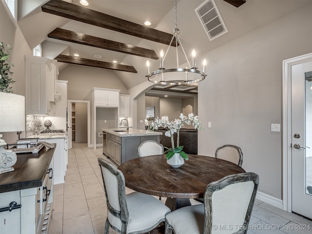 dining area with sink and vaulted ceiling with beams