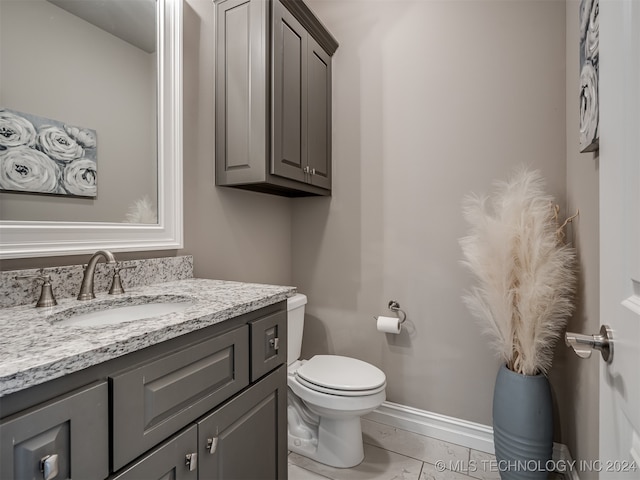 bathroom with tile patterned flooring, vanity, and toilet