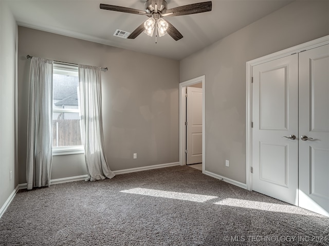 unfurnished bedroom featuring carpet flooring, ceiling fan, and a closet