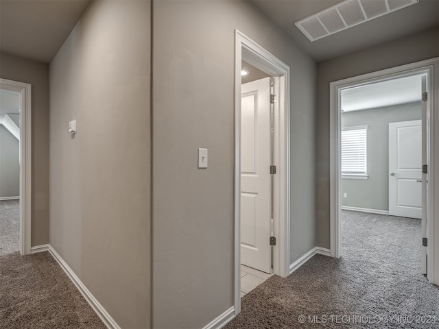 hallway featuring light colored carpet