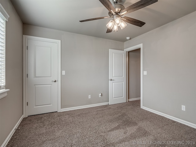 carpeted spare room with ceiling fan