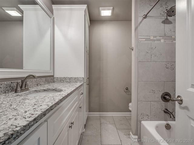 full bathroom featuring vanity, tiled shower / bath combo, and toilet