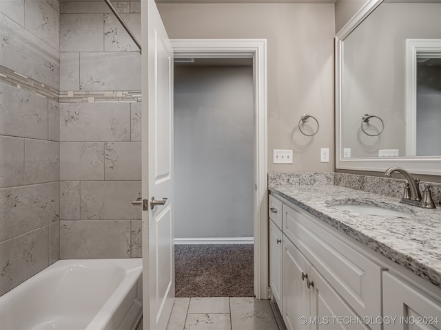 bathroom featuring vanity and tiled shower / bath