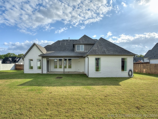 rear view of house featuring a patio area and a lawn