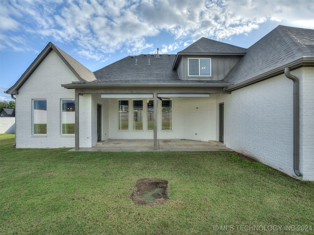 back of property featuring a patio area and a lawn