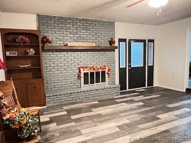 unfurnished living room featuring hardwood / wood-style flooring, ceiling fan, and a textured ceiling