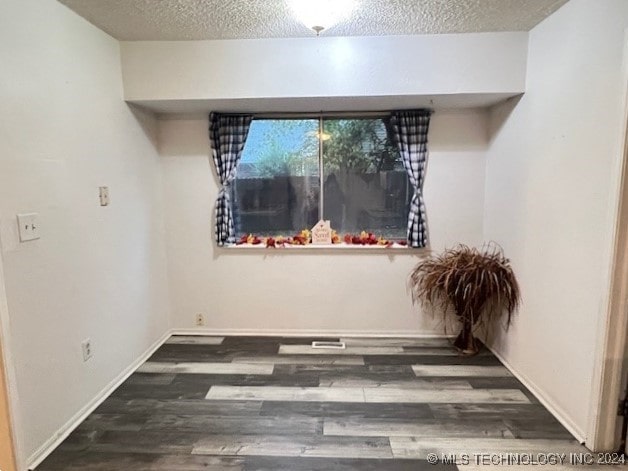 interior space with dark hardwood / wood-style floors and a textured ceiling