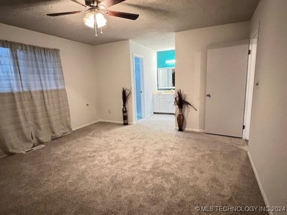 spare room with ceiling fan, a textured ceiling, and carpet flooring