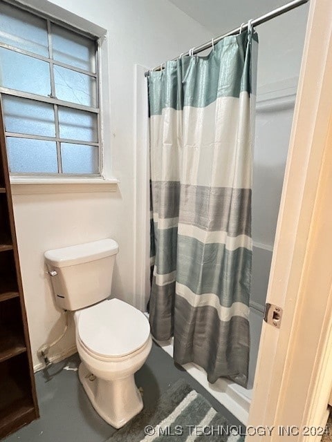 bathroom featuring a shower with curtain and toilet