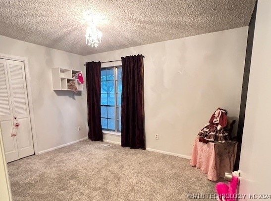 unfurnished bedroom with a closet, light carpet, and a textured ceiling