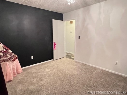 unfurnished bedroom with carpet and a textured ceiling