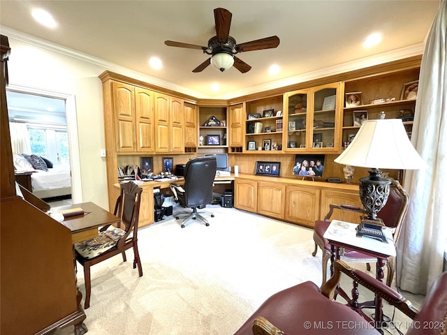 office with ornamental molding, light carpet, built in desk, and ceiling fan