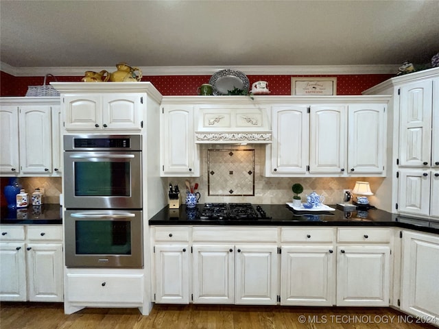 kitchen featuring stainless steel double oven, hardwood / wood-style floors, ornamental molding, and white cabinets