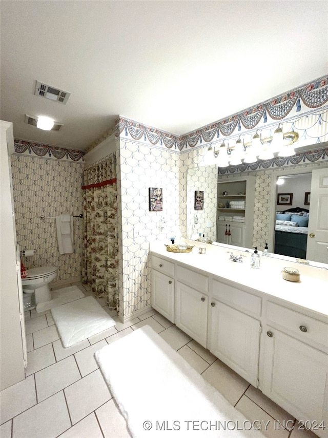 bathroom featuring walk in shower, vanity, tile patterned floors, and toilet