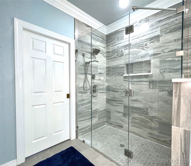 bathroom with tile patterned flooring, crown molding, and a shower with shower door