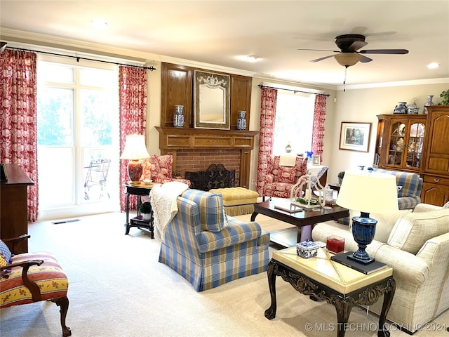 living room featuring a brick fireplace, ceiling fan, light carpet, and crown molding