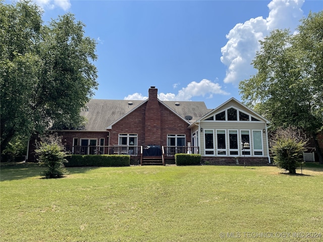 back of house featuring a wooden deck and a yard