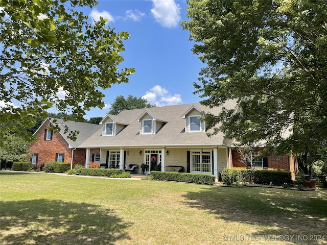 cape cod house with a front lawn