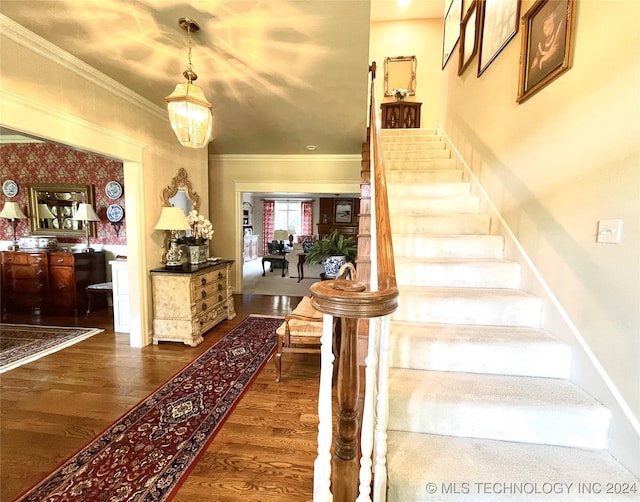 staircase featuring hardwood / wood-style flooring and ornamental molding