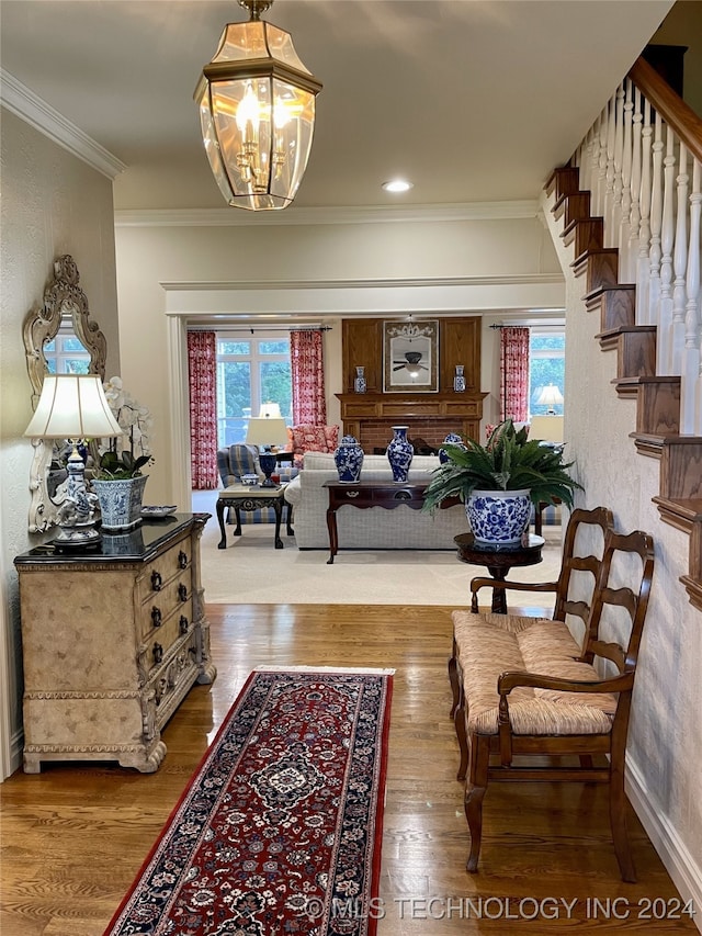 interior space with a chandelier, wood-type flooring, and ornamental molding