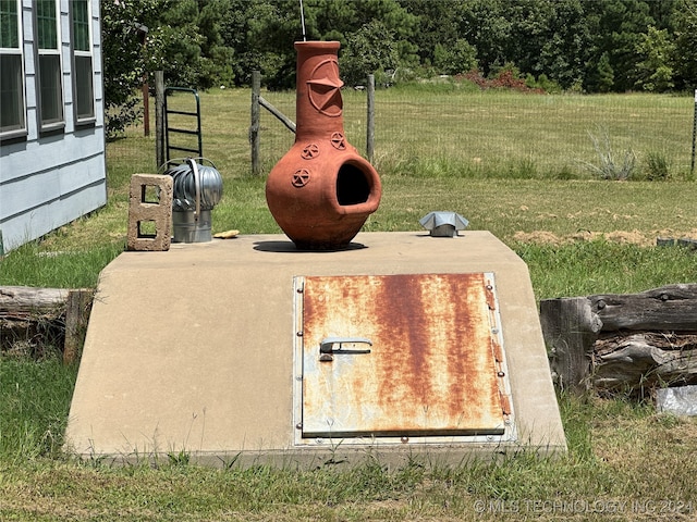 entry to storm shelter featuring a lawn