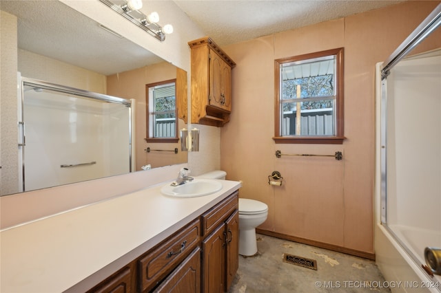 full bathroom featuring vanity, a healthy amount of sunlight, toilet, and a textured ceiling