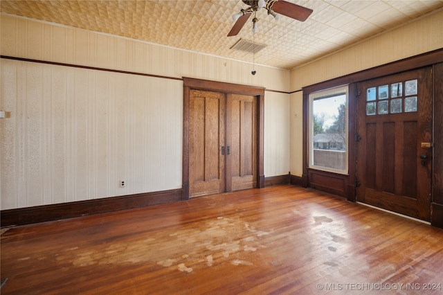 entryway featuring hardwood / wood-style floors, ceiling fan, and wooden walls