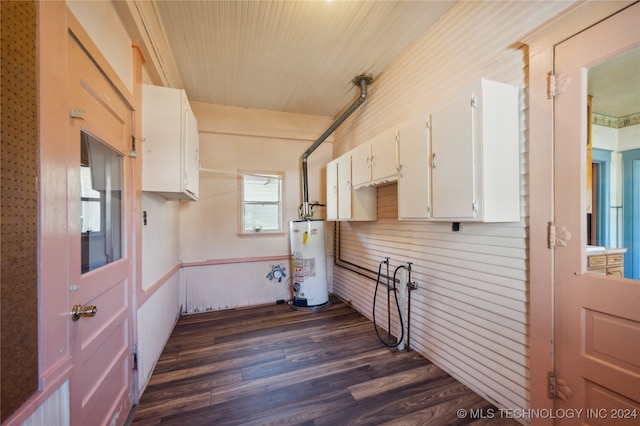 washroom with water heater, wood walls, and dark hardwood / wood-style floors