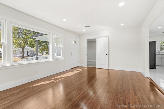 spare room with hardwood / wood-style floors and a healthy amount of sunlight